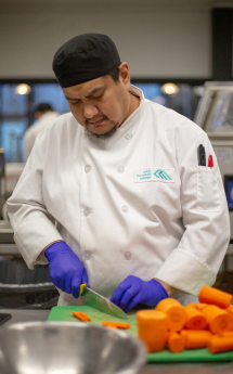 A CMTN student chops carrots during a culinary course