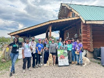 The marketing field school class stands in front of a rural business.